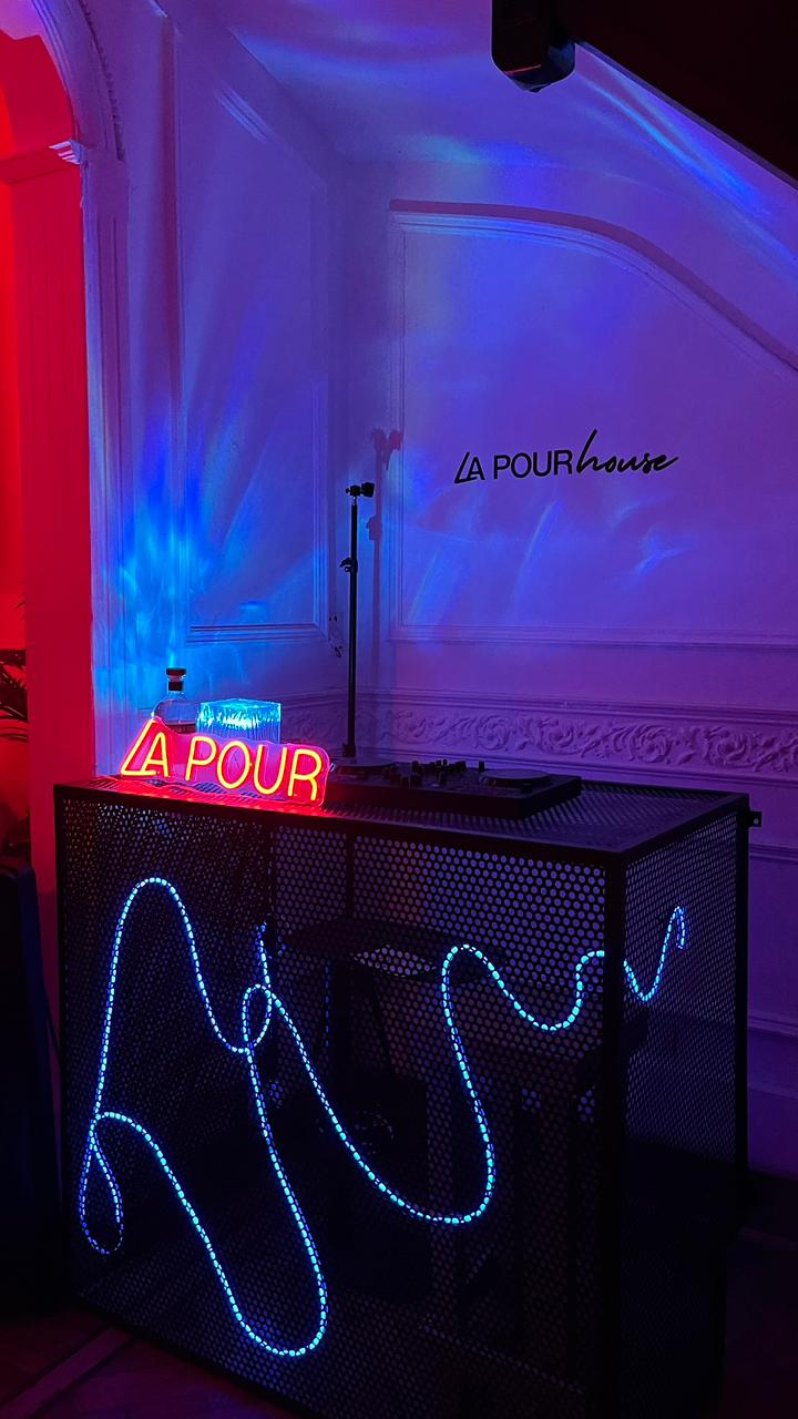 Neon-lit DJ booth at La Pour House Latin dance bar