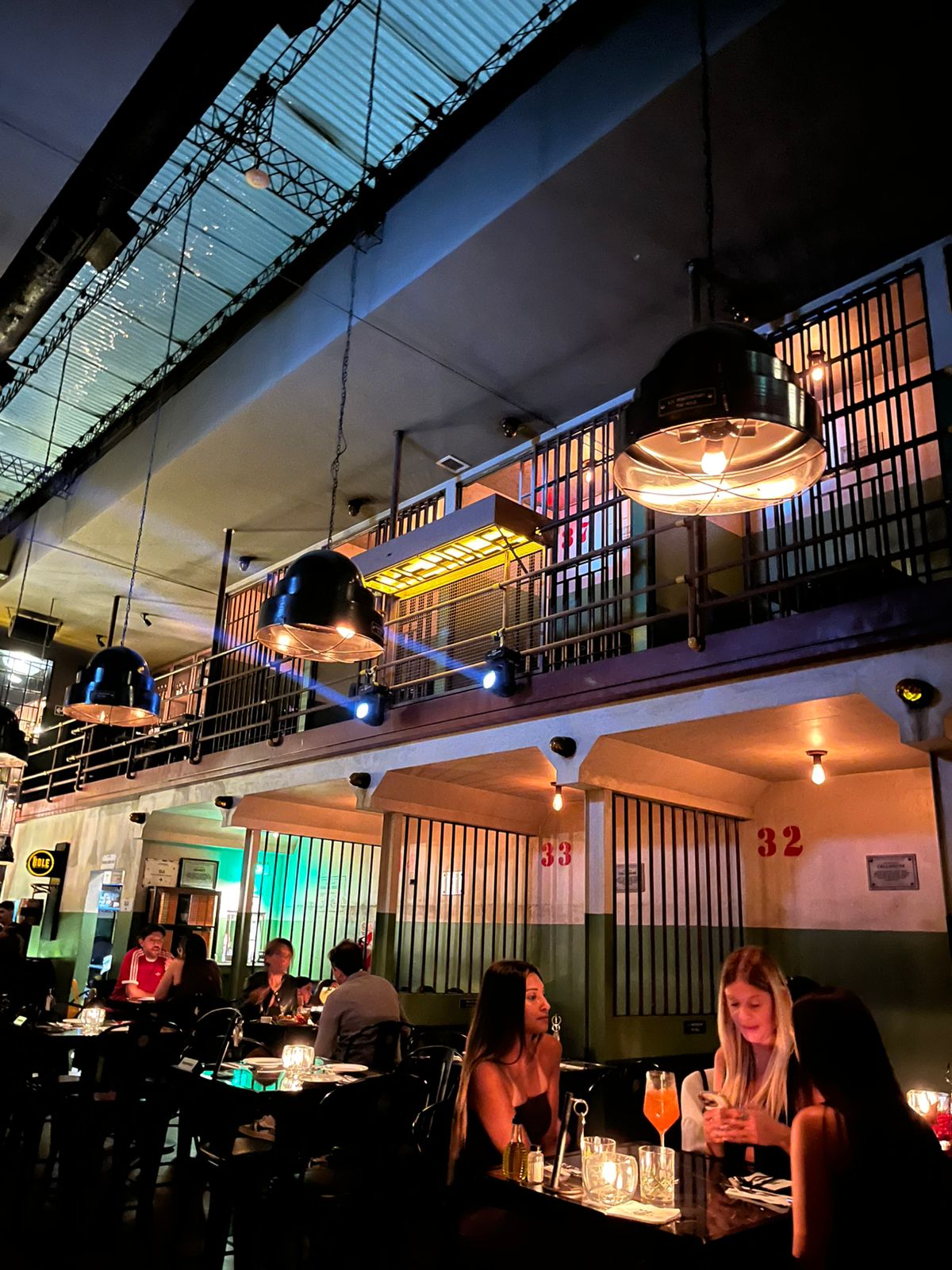 Alcatraz-inspired prison speakeasy interior with cell-block bars